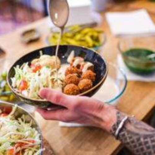 Falafel na talíři s tahini omáčkou a zeleninou